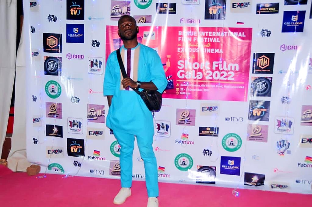 A guest posing in front of the Short Film Gala 2022 backdrop